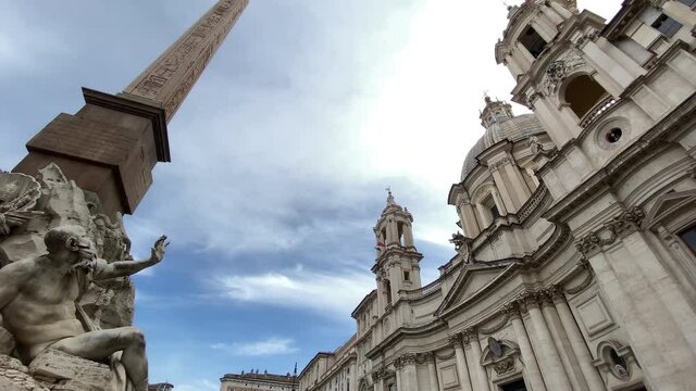 Piazza Navona in Rome on a cloudy day. Panning from the facade of the church of Santa Agnese to the Fountain of the Four Rivers.