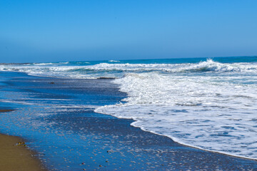 Beautiful blue Pacific Ocean crashing waves tide on beach