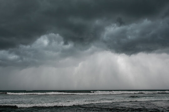 Dark storm clouds in the sky over the sea. Storm cyclone over the ocean. Weather warning. Forces of nature © EVISUAL