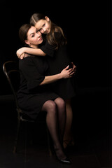Fototapeta na wymiar Mom and daughter in the studio on a black background.