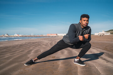 Athletic man stretching legs before exercise.