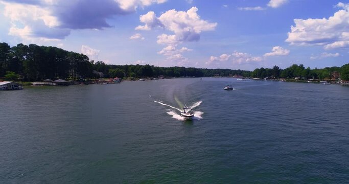 Speed boating on sunny day, aerial drone shot, Lake Norman, NC