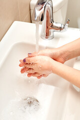 White Child Washing Hands with Soap and Running Water over Sink, Fingers Interlocked