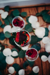 Chocolate Covered Strawberries in a wine glass surrounded by rose petals 
