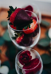 Chocolate Covered Strawberries in a wine glass surrounded by rose petals 