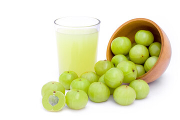 Closeup fresh organic Indian gooseberry fruits ( Amla ) in wooden bowl and glass of gooseberry juice isolated on white background. Antioxidant fruit, herbal medicine plant and healthy drinks concept. 