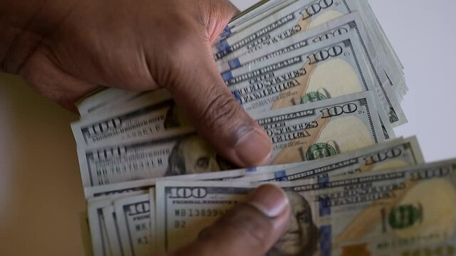 hands of african american or black man counting united states money