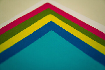 Hojas de colores arcoiris, una tras otra, sobre un fondo claro