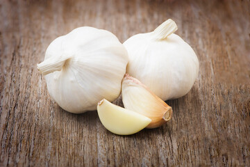 Close up garlic bulb and clove isolated on wood table background. Healthy food or herbal natural medicine plant concept.