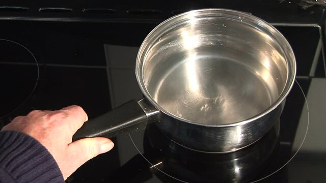 Boiling a pan of water on a kitchen hob aerial view