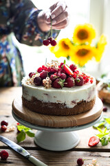 Woman's hands hold homemade berry cheesecake, selective focus. vertical