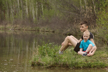 Fototapeta na wymiar Children on a river in a forest catch fish