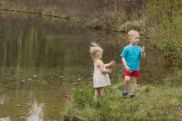 Children on a river in a forest catch fish