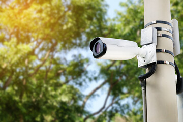 Modern public CCTV camera on a electric pole with blurred natural background. Intelligent reccording cameras for monitoring all day and night. Concept of surveillance and monitoring with copy space.