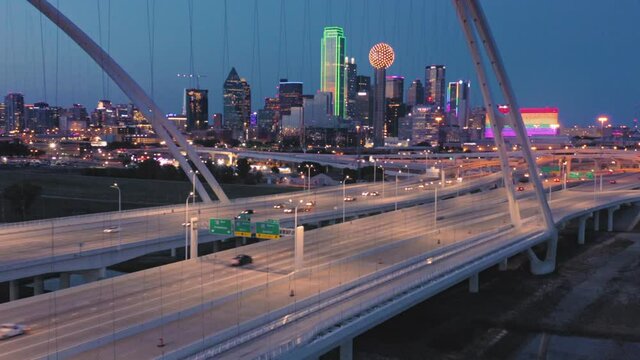 Aerial: Traffic crossing the Margaret Mcdermott Bridge over the Trinity River & downtown Dallas at night. Texas, USA
