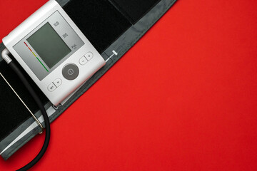 Blood pressure check. Health monitor for check doctor blood pressure isolated on red background. Patient test hypertension from medical sphygmomanometer. Flat lay, top view, copy space.