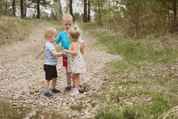 Children on a river in a forest catch fish