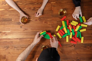 A company of young people is playing a falling tower board game. Friendship and fun concept. Among friends and they are in a good mood. Top view. Copy space.