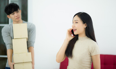 Asian woman customer from online shopping calling to  order and delivery package in living room