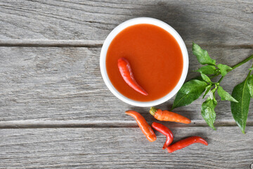 Top picture of chilli sauce on a gray wooden board, food preparation concept