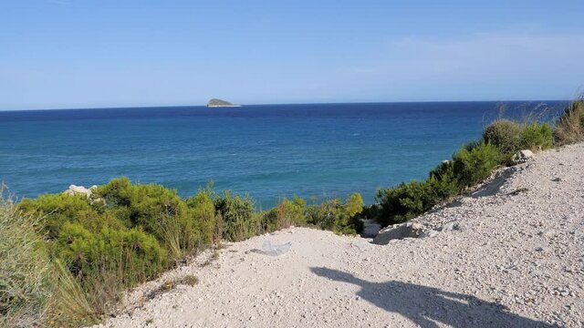 Volunteers cleaning beach from plastic. Boy walking near the sea and picking up plastic bottles trash and putting into plastic bag for recycle