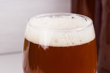 beer foam in glass of home made craft beer from light malt  on white background.  Ale or lager from pilsner malt