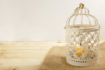 Close up shot of candle lantern on a burlap and wooden table