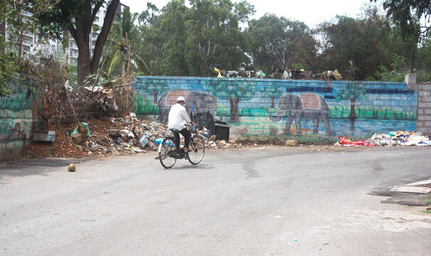 Old man going to home by cycle. man wearing face mask and riding bike in empty road. corona lock down. - Powered by Adobe