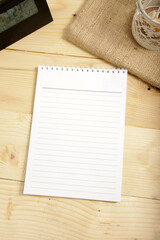 Picture of wooden table that contain paper, eye glasses, desk clock, and candle lantern