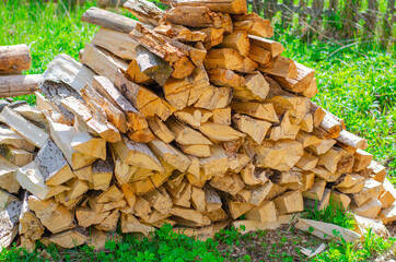 A pile of wood for kindling. Big pile of firewood. Deforestation, forest clearing, in the backyard and forest. 