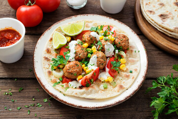 Tortilla with grilled meatball, corn and fresh salad.