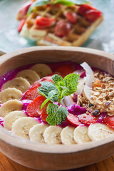   Breakfast style fruits bowl with cereal and belgian wafer