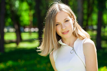 Naklejka premium Portrait of a young beautiful blonde woman in green flowers dress