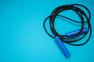 Blue Jumping rope on blue background. Top view. Free copy space for text.