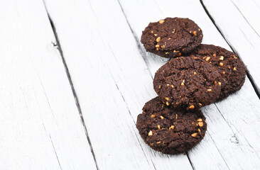 Chocolate biscuits on white wood.Close Up of a group of assorted cookies. Chocolate chip, oatmeal craisin, white chocolate fill the frame. Cookies on wooden table.