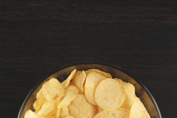 Plate of potato chips on the black table