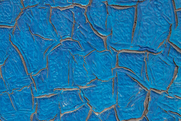 The blue paint on the metal cracked from the effects of natural phenomena, textured image obtained.