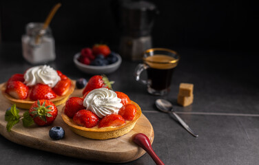Fototapeta na wymiar Homemade dessert strawberry pie with raspberry's and blue berry's and a coffee.