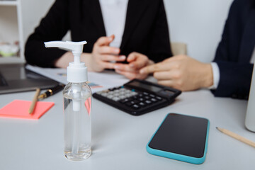 Close-up of workspace with antiseptic gel to disinfect hands in an office. Preventive measures...