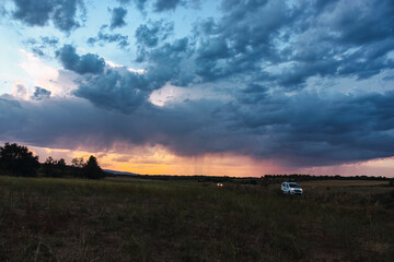Obraz premium Landscape of a stormy afternoon with two cars escaping from the thunderstorm.