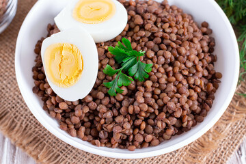 Lentil and egg on white plate