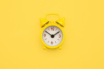 Yellow alarm clock Isolated on yellow trendy background. Rest hours time of life good morning night...
