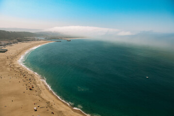 View from above of a beach in the coast of Portugal with tourists enjoying the sun