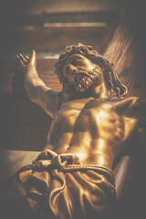 Bottom view of ancient statue of the crucifixion of Jesus Christ. Retro styled image.