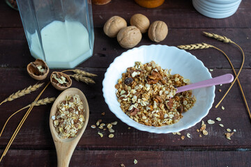 Healthy muesli with milk and nuts in a plate on a wooden table. Healthy lifestyle