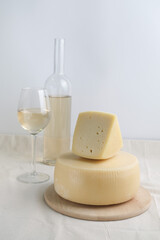 Homemade cheese on wooden plate at light background.