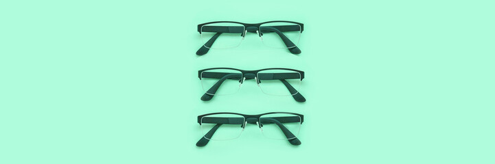 glasses lying on a green background. horizontal banner. top view.
