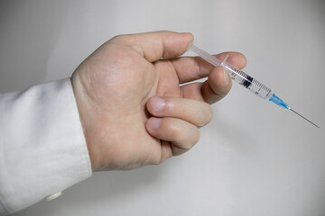 Syringe in a hand on a white background