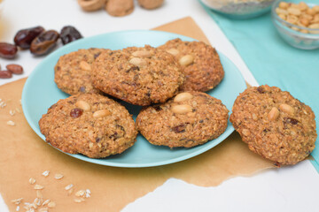homemade oatmeal cookies with dates, peanuts, coconut shavings, macro close-up. broken cookies in the foreground. space for text.