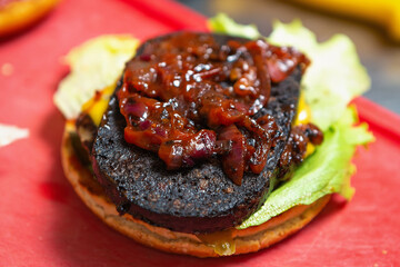 Cooking burger with blood puddling steak,caramelized onion,lettuce salad on crusty bun.Delicious...